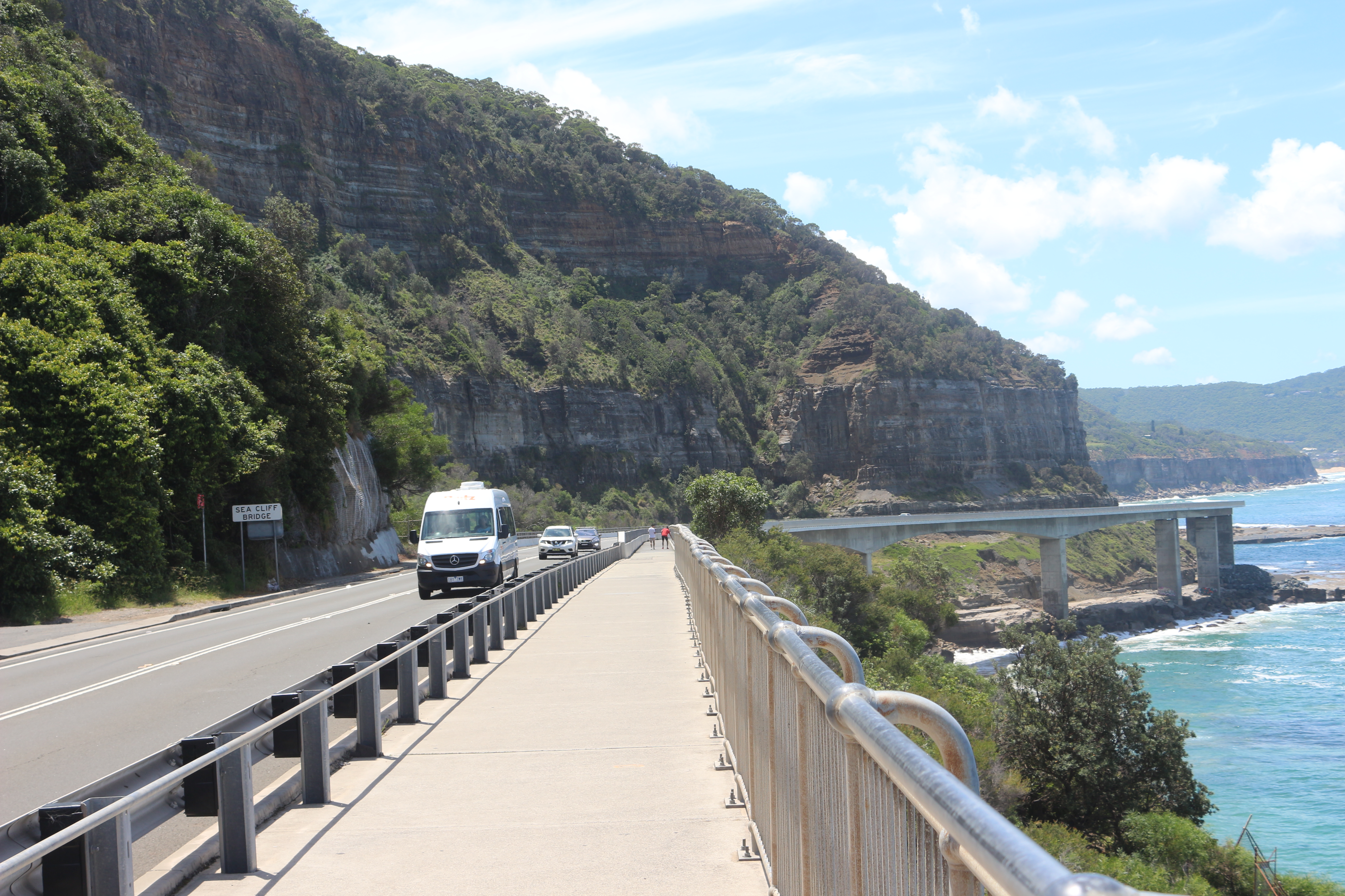 Cars drive along the Sea Cliff Bridge along the Grand Pacific Drive in Australia.